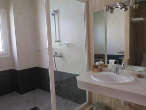 a bathroom with a sink and a shower with a glass door at La Luna Blanca in Torremolinos