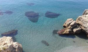 a group of rocks in the clear blue water at La Luna Blanca in Torremolinos