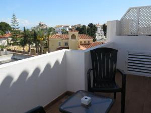 a chair sitting on a balcony with a view of a city at La Luna Blanca in Torremolinos