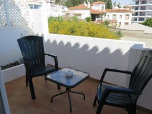 two chairs and a table on a balcony at La Luna Blanca in Torremolinos
