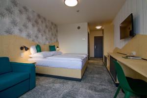 a hotel room with a bed and a blue couch at Hotel Srní a Depandance in Srní +101 photos