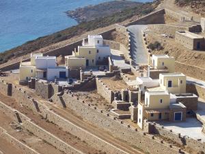 a group of buildings on a hill near the ocean at Monolithos Villas in Kipri