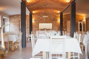 een eetkamer met witte tafels en witte stoelen bij Agriturismo Il Capitolo in Carpaneto Piacentino