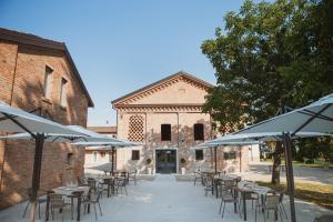 Carpaneto PiacentinoAgriturismo Il Capitolo的建筑物前一排带雨伞的桌子