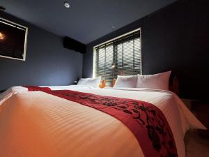a bedroom with two beds and a window at CHULAX OKINAWA YOMITAN【Designer Condominium Hotel】 in Yomitan
