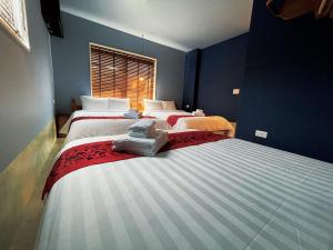 two beds in a room with blue walls at CHULAX OKINAWA YOMITAN【Designer Condominium Hotel】 in Yomitan