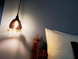a lamp hanging from a wall next to a bed at CHULAX OKINAWA YOMITAN【Designer Condominium Hotel】 in Yomitan