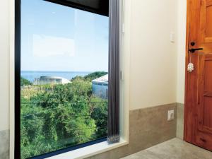 a window in a room with a view of the ocean at CHULAX OKINAWA YOMITAN【Designer Condominium Hotel】 in Yomitan