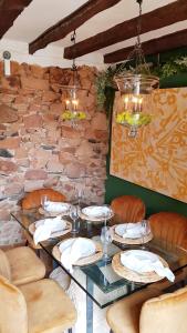 a table in a restaurant with a stone wall at Palacete Maria Rosa in Baños de la Encina