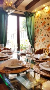 a dining room with a table with plates and wine glasses at Palacete Maria Rosa in Baños de la Encina