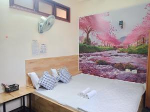 Habitación con cama y pintura en la pared en Khách sạn Duy Hoàng, en Buon Ma Thuot