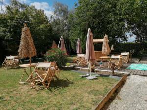 een groep stoelen en parasols naast een zwembad bij le Ricordeau in Domagné