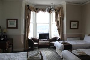 a hotel room with two beds and a window at Headlands Hotel in Llandudno