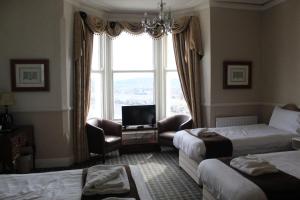 a hotel room with two beds and a window at Headlands Hotel in Llandudno