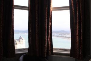 a window with a view of a beach and the ocean at Headlands Hotel in Llandudno