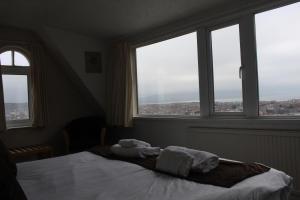 a bedroom with two towels on a bed with windows at Headlands Hotel in Llandudno