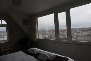 a bedroom with a bed in front of windows at Headlands Hotel in Llandudno