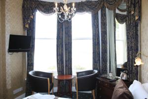 a hotel room with a table and chairs and a window at Headlands Hotel in Llandudno