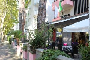 una calle con un edificio con árboles y plantas en Hotel Nascente, en Riccione