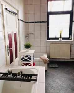 baño con lavabo, bañera y ventana en Ferienwohnung Eddelhoff, en Walsrode