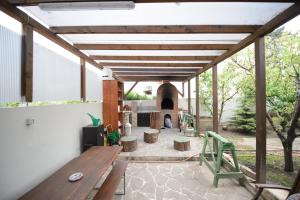 a patio with a wooden table and a fireplace at Tuya Residence in Eforie Nord