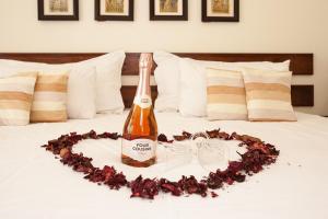 a bottle of champagne on a bed with a heart at Touraco Guesthouse in Pretoria