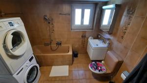 Appartement Le 18 في Ependes: حمام صغير مع غسالة ومغسلة