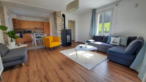 a living room with a blue couch and a table at Appartement Le 18 in Ependes