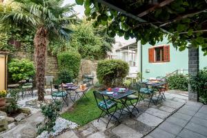 a patio with tables and chairs and a palm tree at Miracolo di Mare Retro in Piran +20 photos