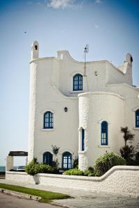 a white building with windows on top of it at Brisas Hosteria in Santa Clara del Mar