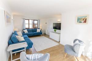 克羅伊德的住宿－Rockpool - Attractive and spacious retreat near Croyde beach - Sleeps 8，客厅配有蓝色的沙发和椅子