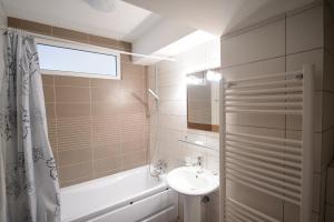 a bathroom with a sink and a toilet and a tub at Tuya Residence in Eforie Nord +7 photos