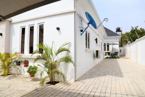 une maison blanche avec une cour ornée de plantes dans l'établissement Rhodabode Apartments. A Luxury 3 bedroom bungalow., à Abuja