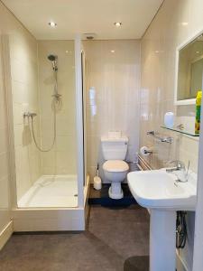 a bathroom with a shower and a toilet and a sink at The Grosvenor in Clacton-on-Sea +78 photos