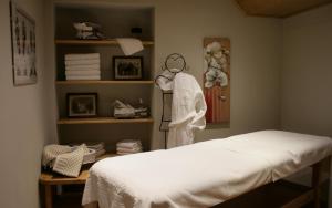 a bedroom with a bed and a shelf with towels at Hotel Larice Bianco in Bormio