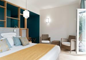 Cama ou camas em um quarto em Hôtel Les Costans, The Originals Relais