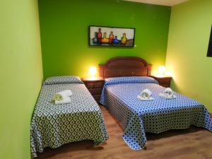 two beds in a room with green walls at Spacious Villa with Private Pool, Villafranca De Los Caballeros in Villafranca de los Caballeros +36 photos