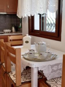 een tafel met een theeservies in de keuken bij Eleni Beach Apartments in Nikiti
