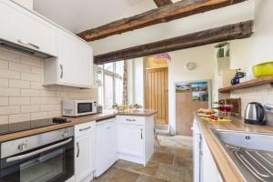 a kitchen with white cabinets and a sink at The Elbow in Dorchester