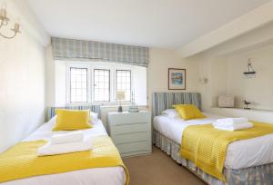two beds in a bedroom with yellow and blue at The Elbow in Dorchester