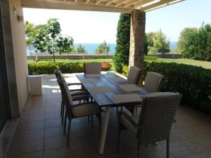 Una mesa de comedor y sillas en un patio. en Villa Achilleos, en Possidi