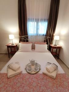 een slaapkamer met een groot wit bed en 2 tafels bij Eleni Beach Apartments in Nikiti