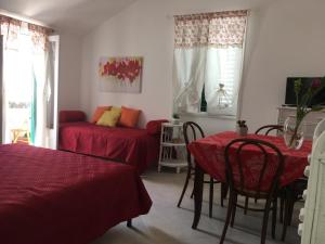 a room with two beds and a table and a couch at Appartamenti La Gina & La Palmira in Otranto