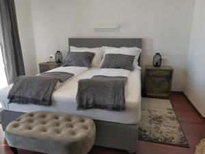 a bedroom with a large bed with pillows and a stool at Villa Diamond in Žrnovnica