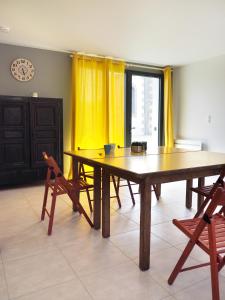 uma sala de jantar com uma grande mesa de madeira e cadeiras em Gîte Les Pingouins du Phare em Plouguerneau