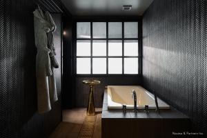 a bathroom with a bath tub and a window at The Tower Hotel Nagoya in Nagoya