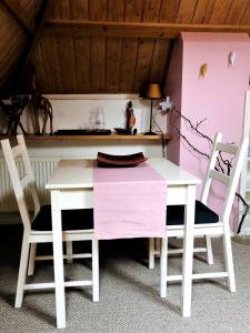 een witte tafel en 2 stoelen in een kamer bij De Buurvrouw Nr.18 in Doesburg