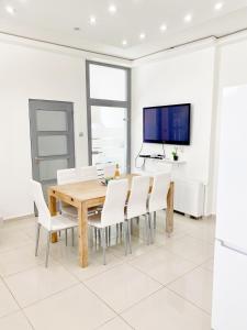 ein Esszimmer mit einem Holztisch und weißen Stühlen in der Unterkunft LUXURY apartment in the centre with a place for barbecue party in Budapest