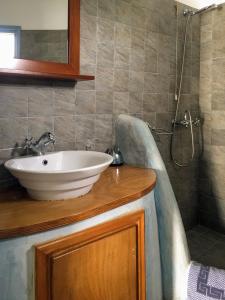 uma casa de banho com um lavatório e um chuveiro em Anatoli em Áno Meriá