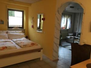 a bedroom with a bed and a living room at Ferienwohnung Weisbrod, nur private Buchungen in Bräunlingen
